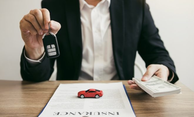 Car salespeople are holding car keys by submitting to new car buyers with car insurance concept.